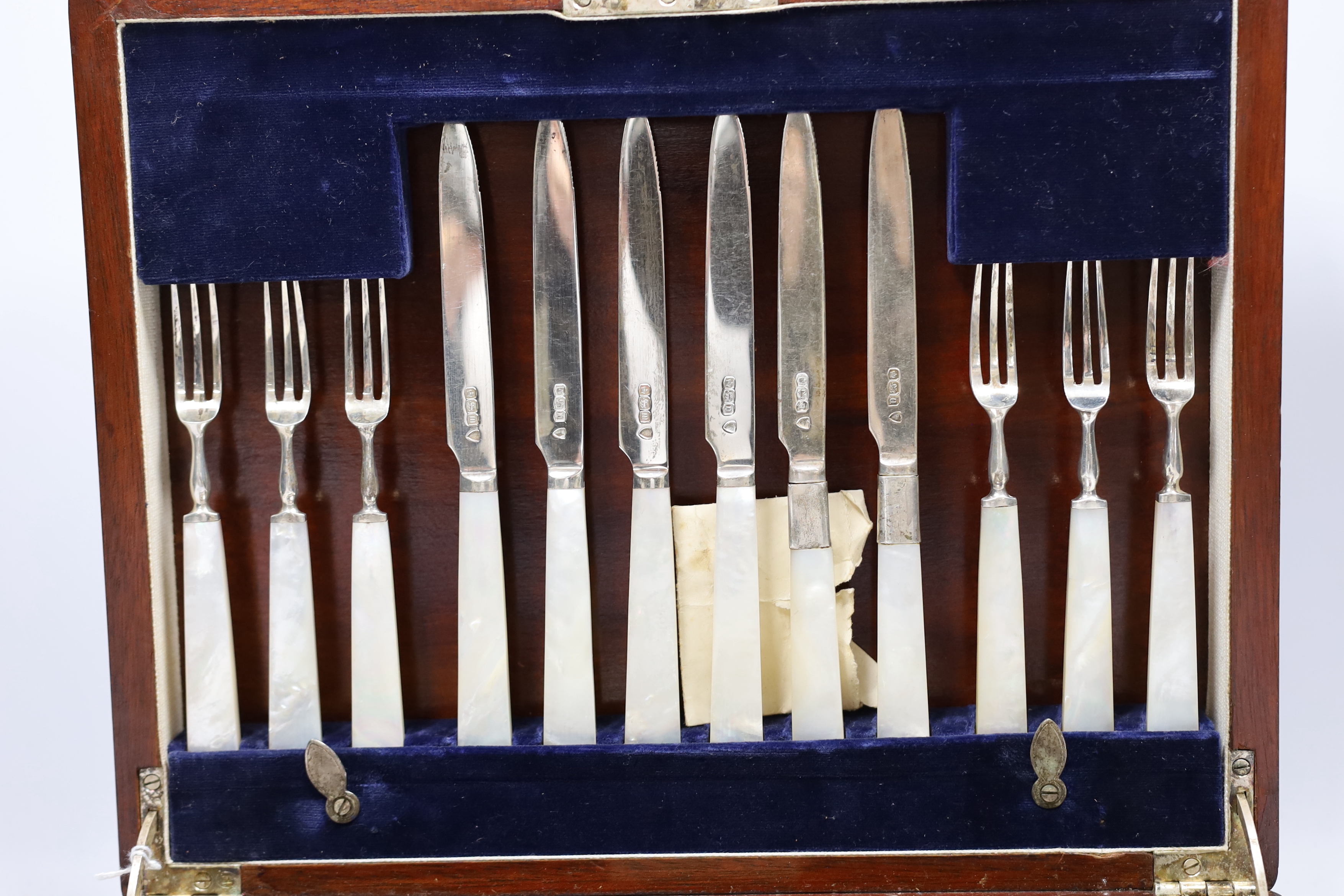 A cased set of twelve pairs of George V silver mother of pearl handled dessert knives and forks, Sheffield 1914, in Belfast Retailer's box